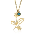 Gold birthstone necklace featuring a floral branch pendant with a blue crystal gem - December Holly (Blue Stone)