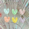 Close-up of heart-shaped resin charms in pastel macaron colors on decorative tray - Letter V