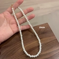 6mm round white pearl necklace with gold lobster clasp on a rustic wooden surface - 6MM Pearl Necklace (Titanium Steel Non-Fading)