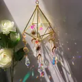 Golden pyramid crystal suncatcher pendant with prisms creating a rainbow light effect - US 12