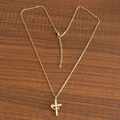 Polished gold cross necklace with white zircon stones on dark wood background - Movable With Crown Cross Gold
