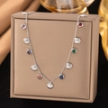 Détail d'un collier argenté avec gemmes colorées et pendentif coquillage sur un présentoir - Coquille Zirconia Colorée (H1320) Acier