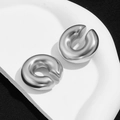 Polished silver stainless steel C-shaped ear cuffs set on an artistic white tray - Smooth Surface Style (F604) / Silver