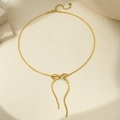 Detail of gold snake bone bracelet featuring a bow charm and lobster clasp - 14k / Gold Necklace