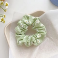 Light green mesh scrunchie featuring white daisy prints and a wrinkled bubble texture - Green Flower