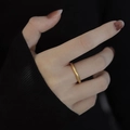 Minimalist 18k gold plated titanium steel plain ring shown on model's index finger - Ancient Gold