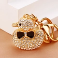 Macro shot of sparkling crystal rhinestones and gold plating on a duck keychain - White Full Rhinestone Duck