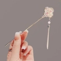 Chinese magnolia hair stick with white petals, pearls, and gold tassels in hand - Plum Blossom Round Fan