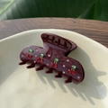 Détail d'une pince à cheveux cerise rouge avec strass sur plateau en céramique - Brun - Quatre Cerises - Pince Crabe Moyenne Strass