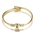 Macro-opname van de 18K gouden kabelarmband met hartvormige bedel en letter R gravure - Letter R