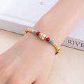 Gros plan d'un bracelet bohème en perles colorées avec un détail de cloche en argent - Compagnon de Vie