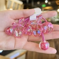 Detailed macro shot of pink acrylic cherry hair ties with shiny iridescent finish - Rose Red