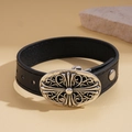 Primer plano de una pulsera de cuero negro con hebilla de cruz de flores de plata vintage - Estilo Cruz (WB1604-1)