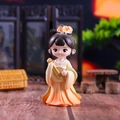 Macro shot of Q-version figurine in yellow dress holding a pipa with a blurred screen background - Zhuo Wenjun