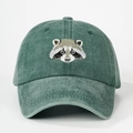 Close-up of raccoon embroidery on green washed cotton baseball cap with fine stitching - One Size / Dark Green