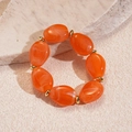 Detail of orange marble resin beads and golden spacers on a stylish statement bracelet - Orange