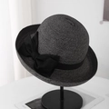 Detail van elegante zwarte strohoed met een grote decoratieve zijden strik als accent. - Zwart