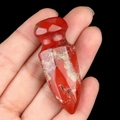 Natural red jasper carved dagger statue with polished finish held in a hand - Red Jasper
