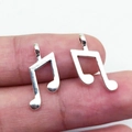 Silver vintage musical note pendants in alloy metal finish shown on fingertips for size - Music Note (8x19mm-0.6g)