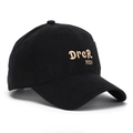 Close-up of golden embroidery on a black cotton baseball cap with detailed stitching - Black