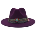 Detail of purple felt cowboy hat featuring turquoise gemstone and colorful bohemian tassels - Deep purple