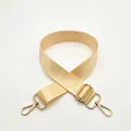 Close-up of beige nylon shoulder strap with adjustable golden metal buckle and lobster clips - Beige
