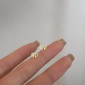 925 silver golden bow stud earrings held on fingertips to show delicate size - Hollow Bowknot / Gold