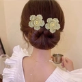 Gros plan d'une pince à cheveux rose dorée avec strass brillants sur un chignon - Fleur Or