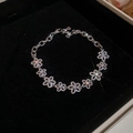 Detailed view of silver hollow floral bracelet with zircon accents on black velvet - Hollow Flower / Silver