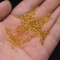 Golden silver-lined glass seed beads for DIY jewelry making held in hand for detail - 2mm / 15g / Light gold