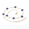 Gold finish necklace featuring blue crystal flowers and bead accents on white background - Blue Necklace
