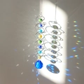 Silver spiral wind chime with colorful crystal beads and blue ball casting rainbow shadows - Medium Blue & White