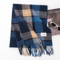Blue and brown plaid scarf with fringe and brand label on a minimalist white background - Sky Blue Plaid