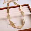 Dettaglio pendente foglia dorata martellata su scatola portagioie elegante - Oro