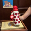 Close-up of white insulated bottle with red heart prints and flower silicone charm - Red Heart