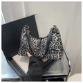 Gros plan du sac baguette léopard avec bandoulière noire et boucle métallique - Noir