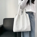 Detail view of a white floral tote bag with black dots worn over the shoulder by a model - Small Polka Dots Beige