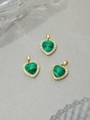 Detalle macro de tres colgantes de corazón de malaquita verde con borde dorado y cristales - Verde Oscuro