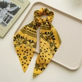 Detail van gele paisley zijden scrunchie met linten op een minimalistisch beige dienblad - Geel Paisley Lint