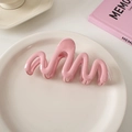 Pink wavy hair claw clip made of glossy plastic displayed on a white ceramic plate - Creamy Pink