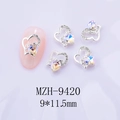Détail macro de breloques à ongles coeur d'argent avec strass sur fond violet clair - Base Argent Aurora Pierre de Lune Blanche Style Zirconia (9420 Pierre de Lune Blanche)