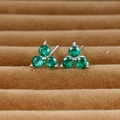 Macro shot of clover-shaped stud earrings featuring three round-cut emerald green gemstones - Silver/Green Zirconia