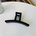 Macro shot of large black matte claw clip with curved teeth and square handle for thick hair - Matte Black