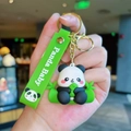 Cute panda baby keychain with green strap and gold hardware held in hand - Gen 2 Sitting Pose
