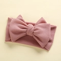 Close-up of pink waffle knit baby headband with a large handmade decorative bow - 17*9 cm / Dusty Rose