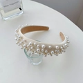 Elegant wide headband with creamy satin fabric and glossy faux pearls on a glass display - Sponge Full Pearl