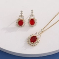 Detail view of gold necklace and earrings set with red oval stones on white platform - Gold Oval Red (HQ0001(5))