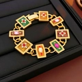 Detail eines Vintage-Goldarmbands mit bunten Emaille-Quadraten und Edelsteinen auf Tablett - Armband-Gold-Mehrfarbig