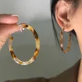 Gros plan de boucles d'oreilles en résine motif écaille avec une texture polie en C - 20# Créoles en écaille de tortue café et jaune avec tige en argent