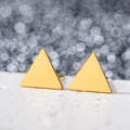 Detail shot of golden geometric triangle earrings with smooth matte finish - Triangle / Gold